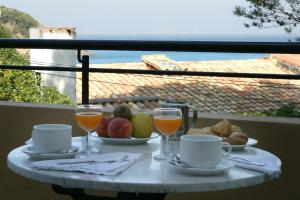 een tafel met eten en glazen sinaasappelsap bij Hotel Sa Riera in Begur