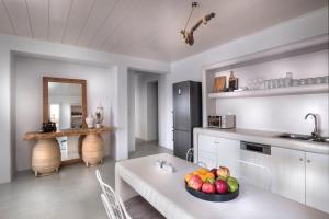 a kitchen with a table with a bowl of fruit on it at Simousi Villas in Kithnos +59 photos