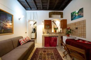 een woonkamer met een bank en een tafel en een keuken bij JUSTACASA alla SCALA Trastevere in Rome