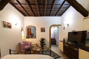 een slaapkamer in een villa met een bed en een televisie bij JUSTACASA alla SCALA Trastevere in Rome