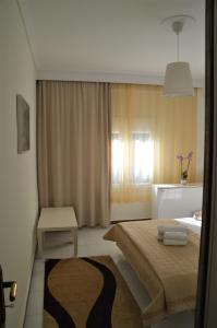 ein Hotelzimmer mit einem Bett und einem Fenster in der Unterkunft Aigaiou House in Thessaloniki