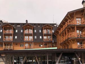 ein großes Holzgebäude mit vielen Fenstern in der Unterkunft Apartment 101 - Aparthotel Vucko Jahorina private host in Jahorina
