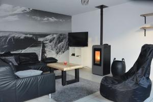 a living room with a couch and a tv and a table at SeaSide4you in De Haan