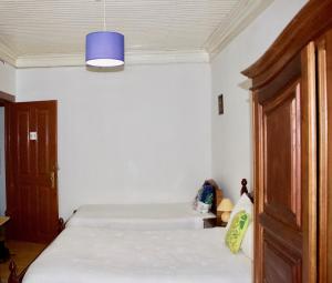 a bedroom with a bed and a blue light at Residencial Rivoli in Fundão