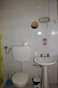 a small bathroom with a toilet and a sink at Residencial Rivoli in Fundão