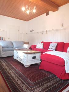 a living room with a red couch and a table at Müllers Ferienhaus Salzburgerland in Unken