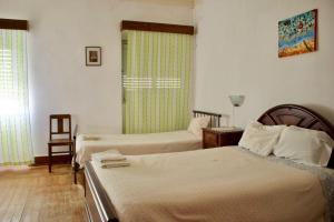 een hotelkamer met 2 bedden en een raam bij Residencial Tarouca in Fundão