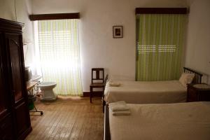 a bedroom with two beds and a sink and a window at Residencial Tarouca in Fundão