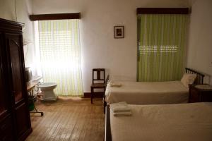1 dormitorio con 2 camas, lavabo y ventana en Residencial Tarouca, en Fundão