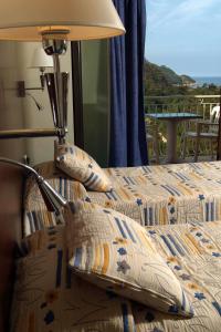 1 dormitorio con 1 cama con almohadas y lámpara en Capo D'orto - Porto - Corse, en Porto Ota