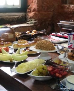 a table topped with lots of different types of food at Pousada Vovô Chiquinho in Tiradentes