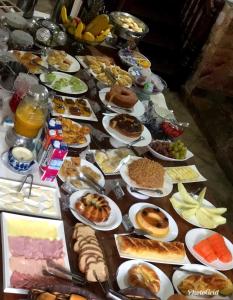 una mesa con muchos platos de comida. en Pousada Vovô Chiquinho, en Tiradentes