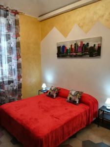 トリノにあるAPPARTAMENTO SPEZIAのベッドルーム1室(赤いベッド1台、テーブル2台付)