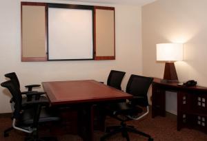 Sala de conferencias con mesa, sillas y espejo en Larkspur Landing South San Francisco-An All-Suite Hotel, en South San Francisco