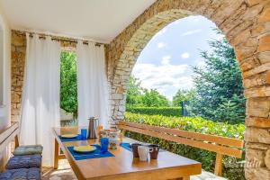 a table in a room with an arched window at Family Vacation Villa in Žbandaj