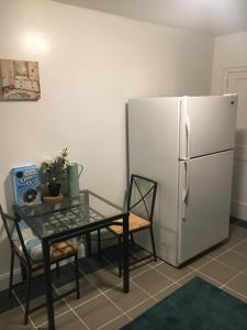 uma cozinha com uma mesa e um frigorífico branco em GORGEOUS HOUSE NEXT JHU em Baltimore