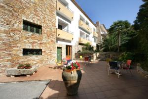 un edificio de ladrillo con un jarrón con flores. en Hotel Sa Riera, en Begur