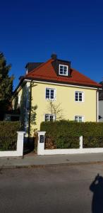 uma grande casa amarela com um telhado vermelho em Helle und ruhige Dachgeschosswohnung em Munique