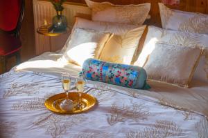 a bed with two glasses and a tray on it at Villa Botanica in Mirkovec