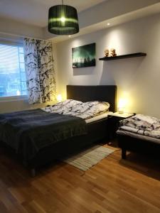 a bedroom with a bed and a table and a window at Arctic Oasis Apartments in Rovaniemi