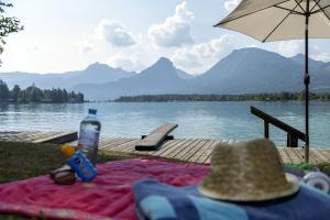 a picnic table with a hat and a view of a lake at Altroiterhof in St. Wolfgang
