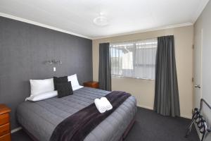 um quarto de hotel com uma cama e uma janela em ASURE Adrian Motel em Dunedin