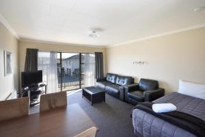 - un salon avec un lit et un canapé dans l'établissement ASURE Adrian Motel, à Dunedin