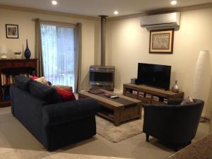 a living room with two couches and a tv at Emerald Creek Cottages in Emerald