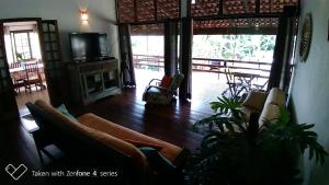 ein Wohnzimmer mit Sofa und Fernseher in der Unterkunft Casa Bela da ilha II in Ilhabela