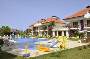 a pool with a slide in front of a house at Yonca Hotel in Adrasan