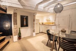 a living room with a table and a kitchen at LE CELESTIN - Centre Historique - in Rennes
