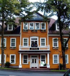 a large orange house with a balcony on a street at Harzhotel Zum Prinzen in Clausthal-Zellerfeld