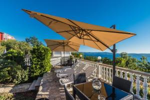 a patio with a table and chairs and an umbrella at Apartment Crikvenica, Vinodol 5 in Crikvenica