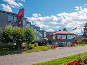 a hotel with a sign on the side of a road at Ramada by Wyndham Kamloops in Kamloops