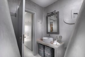 a bathroom with a sink and a mirror at Simousi Villas in Kithnos