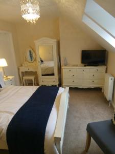 a bedroom with a bed and a dresser and a tv at Garroch House in Carbost