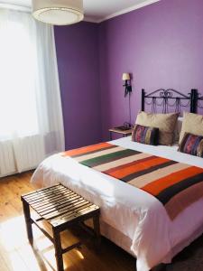 a bedroom with a large bed with purple walls at Hostería La Casa de Eugenia in San Martín de los Andes