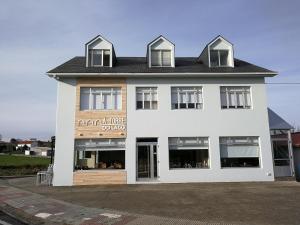 a white building with a sign on the side of it at A Torre do Lago in Valdoviño