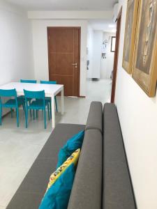 a couch in a room with a table and chairs at Apartamento Completo Jatiúca in Maceió