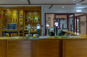 een bar met een bar met alcoholflessen bij Primelodge Rotherham in Hellaby