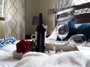 een fles wijn en twee glazen op een bed bij Casa Mirango Boquete in Boquete