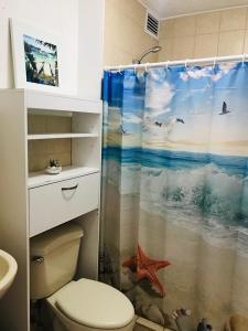 y baño con aseo y cortina de ducha. en Costa Linda Condo 1.3 - Jaco, en Jacó