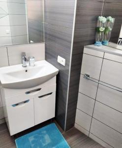 a white bathroom with a sink and a mirror at Apartment "Comfort" in the Center in Chernivtsi