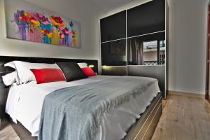 um quarto com uma cama grande e um quadro na parede em apartamento completo centrico em Maracena