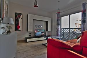 a living room with a red couch and a television at apartamento completo centrico in Maracena