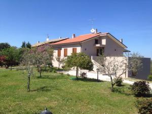 ein Haus auf einem Feld mit Bäumen davor in der Unterkunft Villetta le Rose in Tavullia