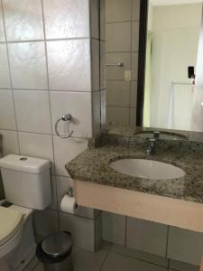 a bathroom with a sink and a toilet and a mirror at Terrazzo Ponta Negra Flat in Natal