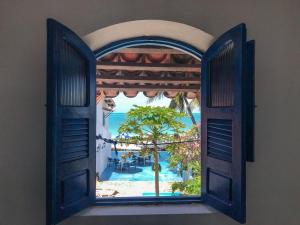 an open window with a view of a resort at Pousada Ruínas do Pilar in Itamaracá