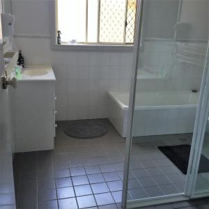 a bathroom with a shower and a tub and a sink at Tic Tac Toe Quality Accommodation in Armidale