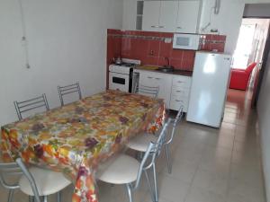 a kitchen with a table with chairs and a refrigerator at Bungalow Anita Nº4 in Colón